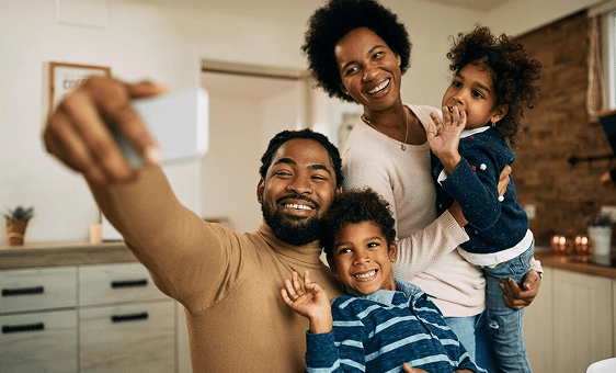 Smiling family taking a selfie together in their kitchen