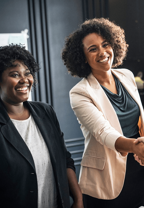 Two smiling businesswomen shaking hands